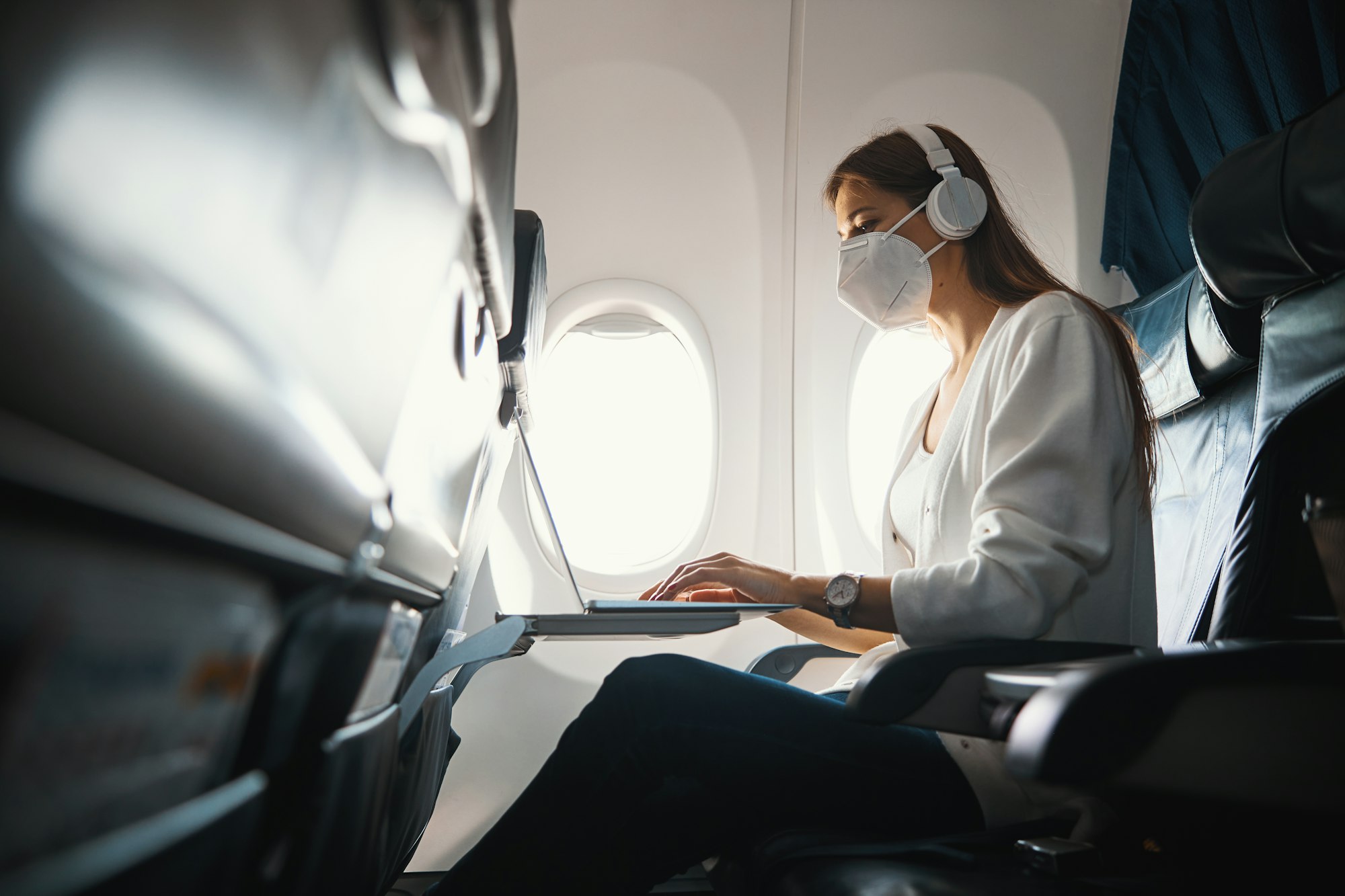 Young lady working on the laptop in the airplane